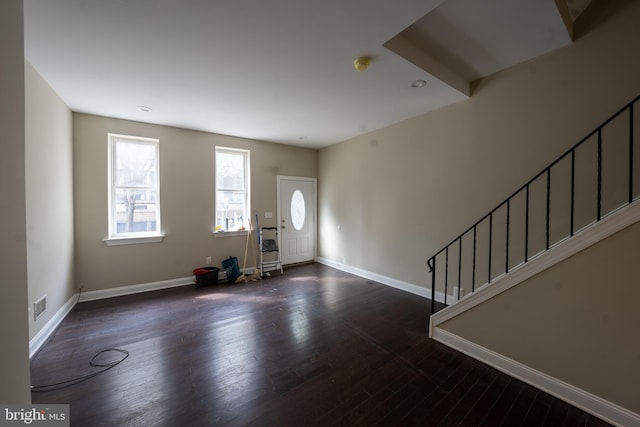 entryway with stairs, wood finished floors, visible vents, and baseboards