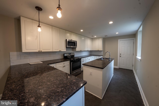 kitchen with recessed lighting, stainless steel appliances, white cabinetry, tasteful backsplash, and a center island with sink