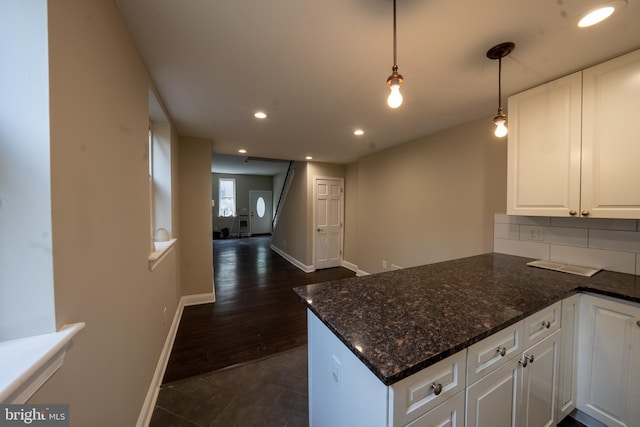 kitchen with tasteful backsplash, recessed lighting, white cabinetry, a peninsula, and baseboards