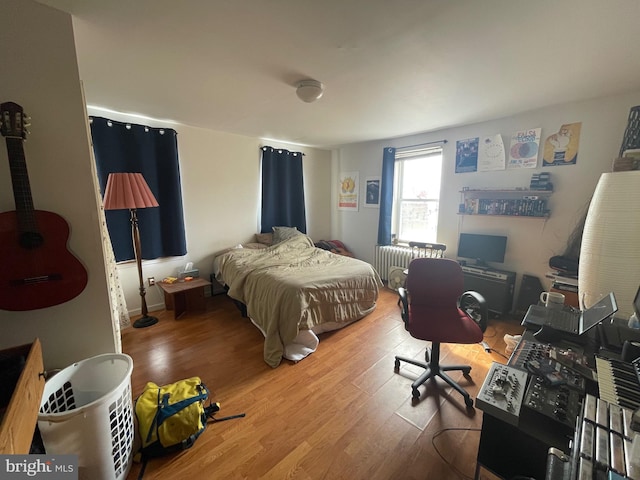 bedroom featuring radiator and wood finished floors