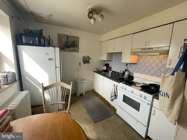 kitchen with radiator, under cabinet range hood, decorative backsplash, white cabinets, and white appliances