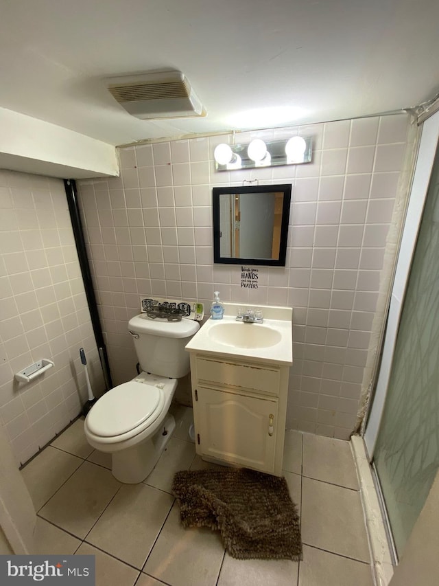 bathroom with tile patterned floors, toilet, tile walls, and vanity