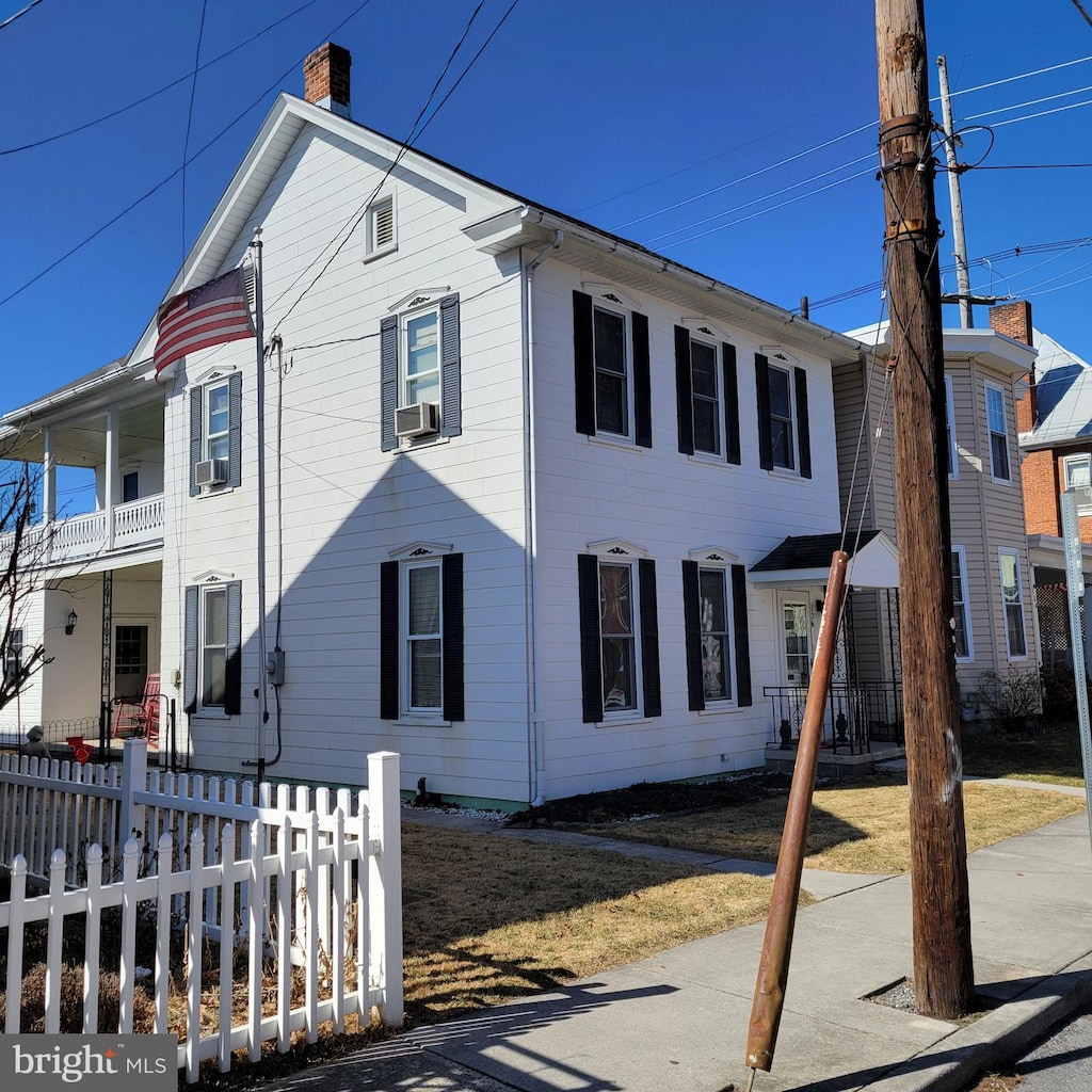 view of side of home with a fenced front yard and cooling unit