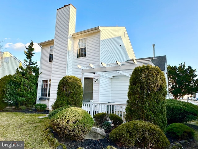 exterior space featuring a chimney and a pergola