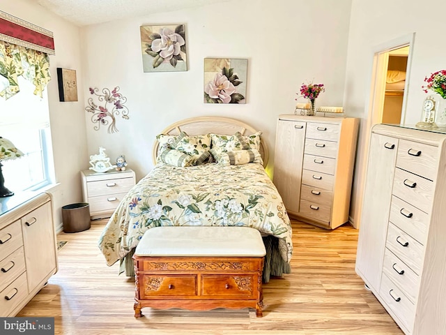 bedroom with light wood-style floors and a textured ceiling