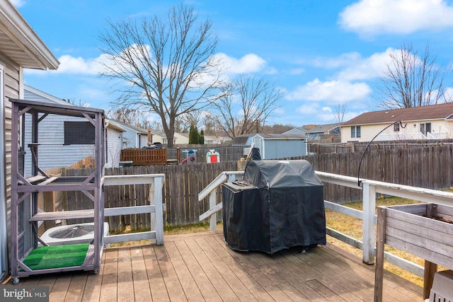 wooden terrace featuring grilling area, a residential view, and fence