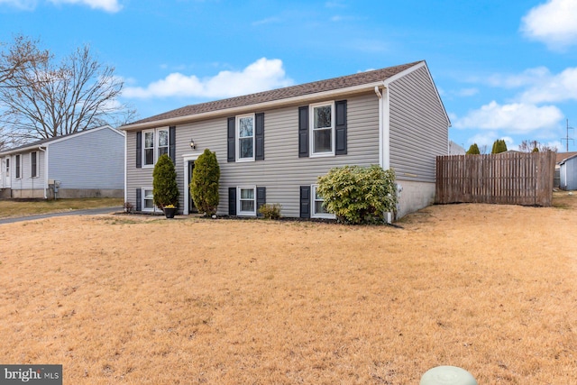 view of front facade featuring a front yard and fence