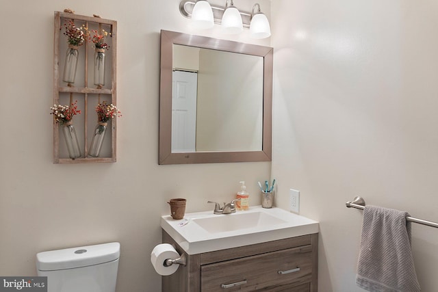 half bathroom with toilet and vanity