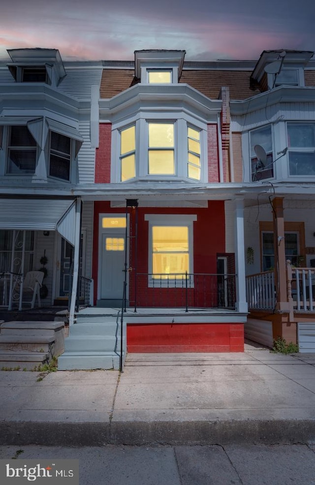 townhome / multi-family property featuring brick siding and a porch