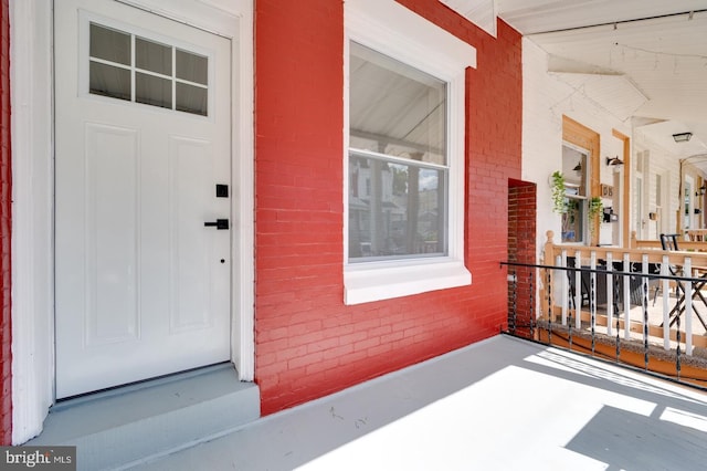 doorway to property featuring brick siding and a balcony