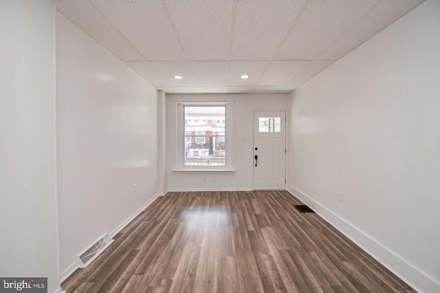 entrance foyer featuring a drop ceiling, visible vents, baseboards, and dark wood-style floors