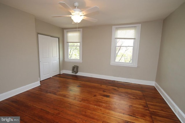 unfurnished bedroom featuring a closet, a ceiling fan, baseboards, and hardwood / wood-style flooring