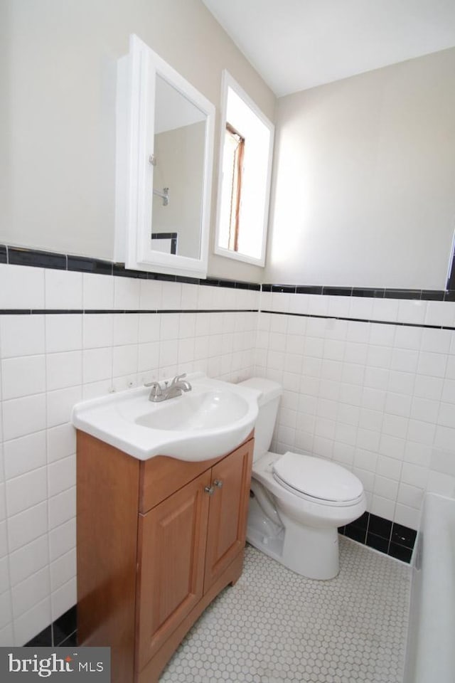 bathroom with vanity, tile walls, toilet, and tile patterned floors