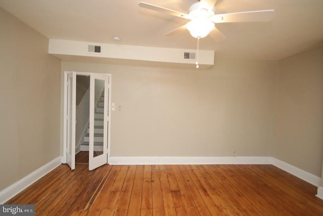 spare room featuring visible vents, baseboards, and hardwood / wood-style floors