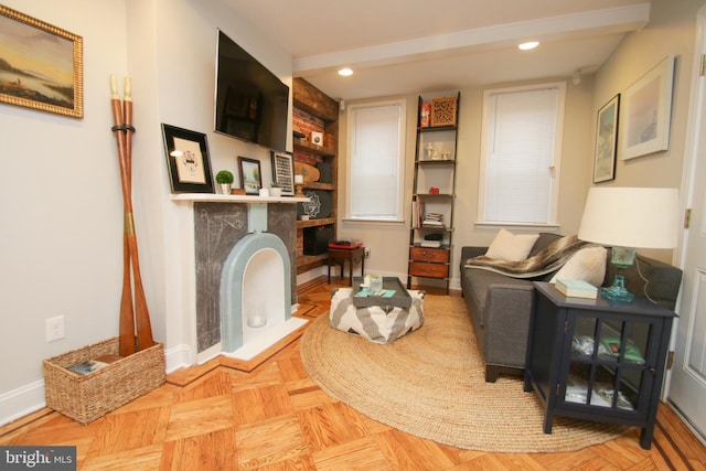 sitting room with recessed lighting, baseboards, and a fireplace with raised hearth