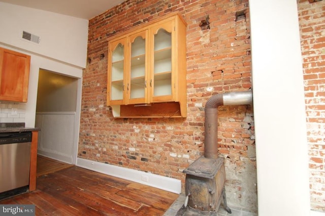 kitchen featuring visible vents, dishwasher, glass insert cabinets, and dark wood-style flooring