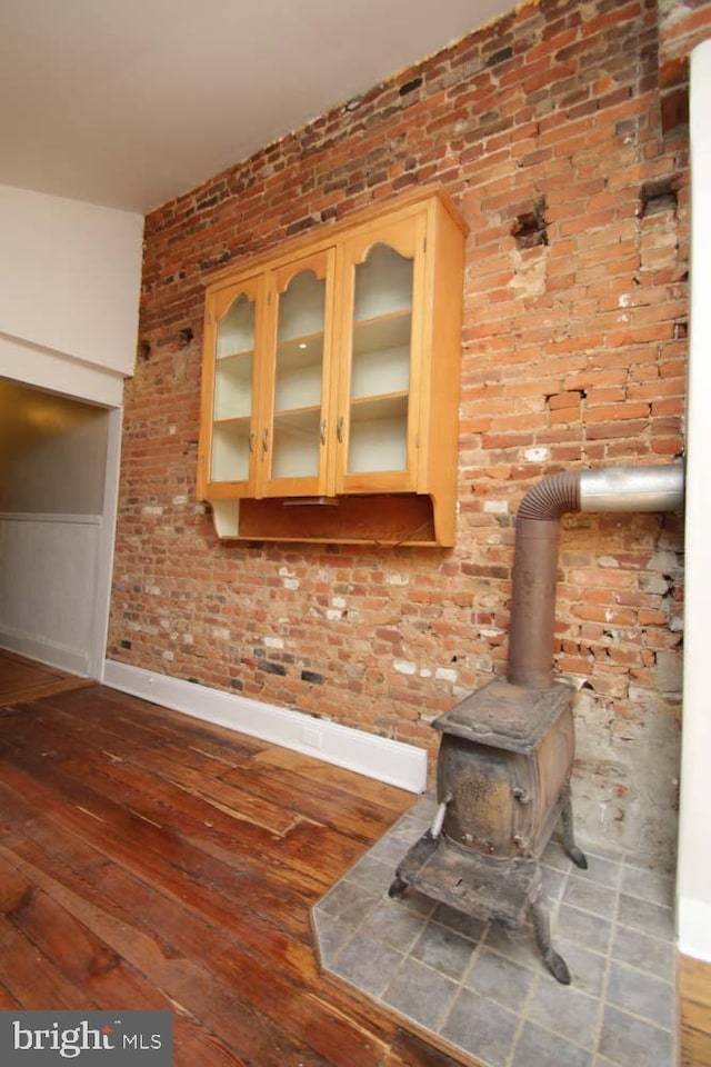 interior details featuring baseboards, wood finished floors, and a wood stove