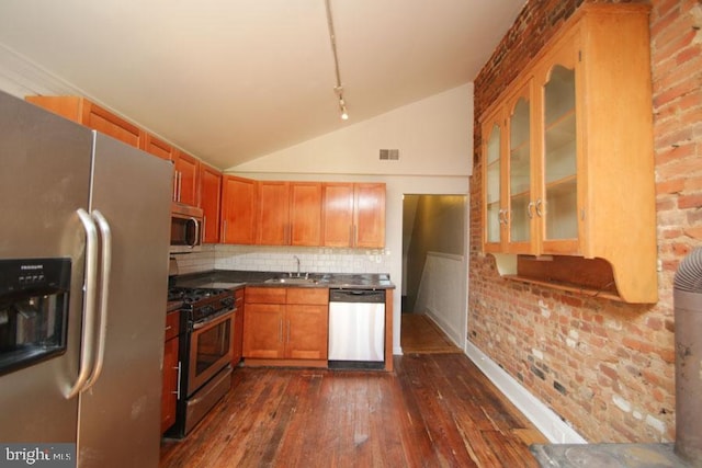 kitchen with decorative backsplash, appliances with stainless steel finishes, glass insert cabinets, lofted ceiling, and dark wood-style flooring