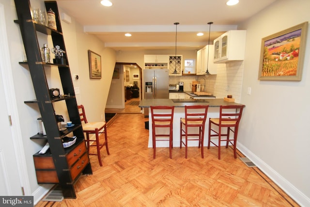 kitchen featuring baseboards, open shelves, a peninsula, decorative backsplash, and stainless steel refrigerator with ice dispenser