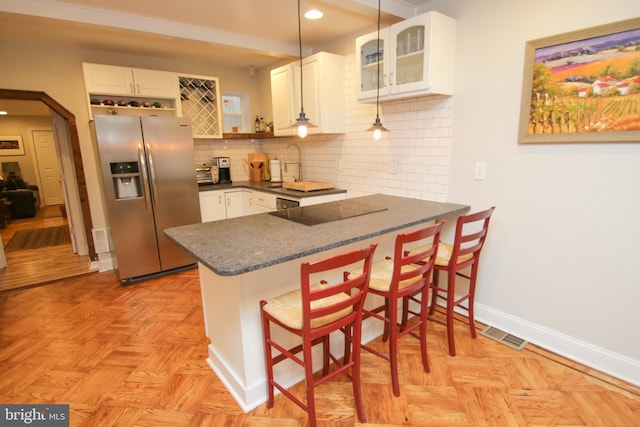 kitchen featuring tasteful backsplash, a peninsula, white cabinets, stainless steel fridge with ice dispenser, and black electric stovetop