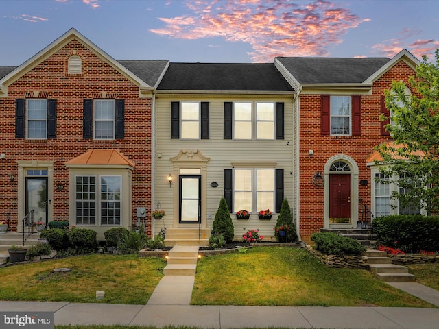 view of property featuring brick siding and a front yard