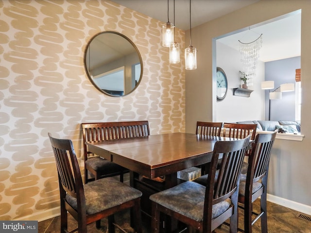 dining space featuring visible vents, baseboards, and wallpapered walls