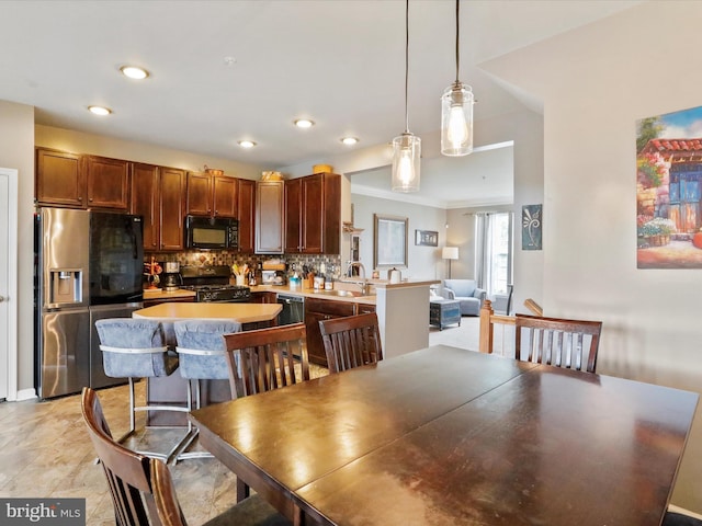 dining room with ornamental molding and recessed lighting