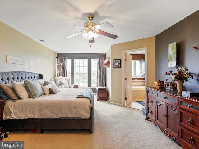 bedroom featuring ceiling fan, connected bathroom, light colored carpet, visible vents, and baseboards