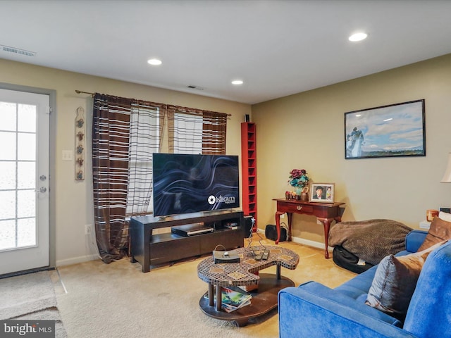 carpeted living area featuring baseboards, visible vents, and recessed lighting