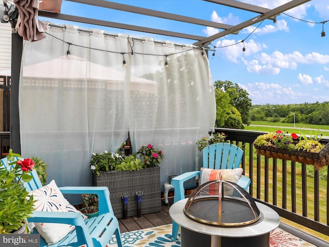 balcony with an outdoor fire pit, a sunroom, and a pergola