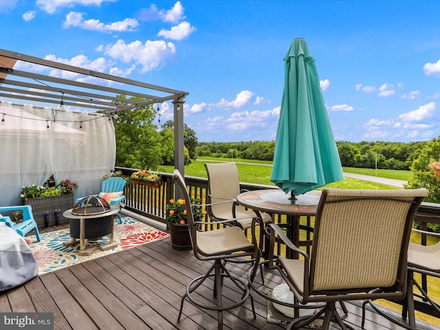 wooden deck featuring an outdoor fire pit, a pergola, and a yard