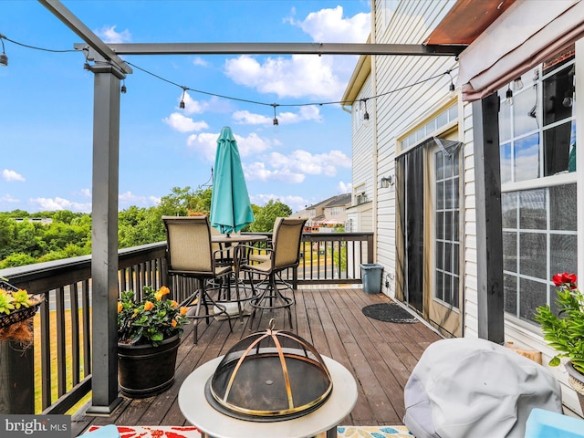 wooden deck with outdoor dining area and area for grilling