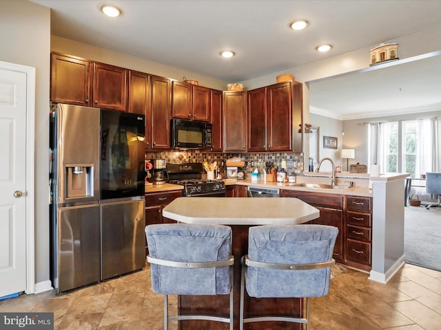 kitchen featuring light countertops, backsplash, a sink, a peninsula, and black appliances