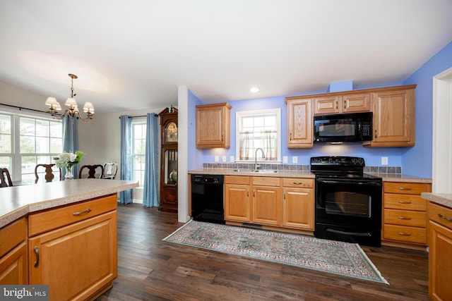 kitchen featuring black appliances, dark wood-style flooring, light countertops, and a sink