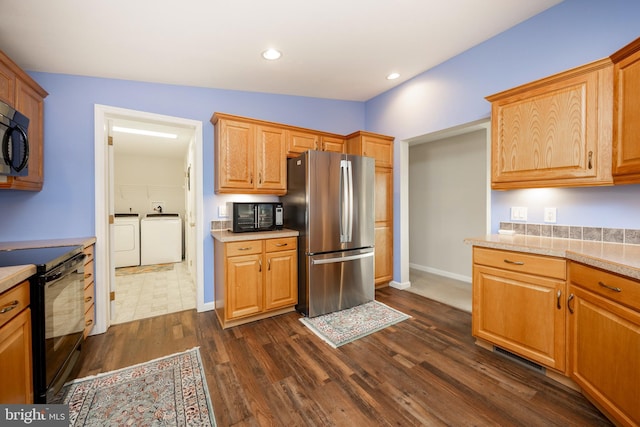 kitchen with dark wood-style floors, washer and clothes dryer, recessed lighting, light countertops, and black appliances