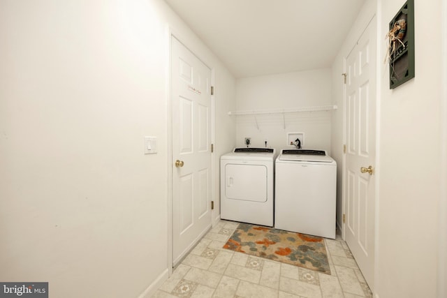 washroom featuring laundry area, stone finish floor, and washing machine and clothes dryer