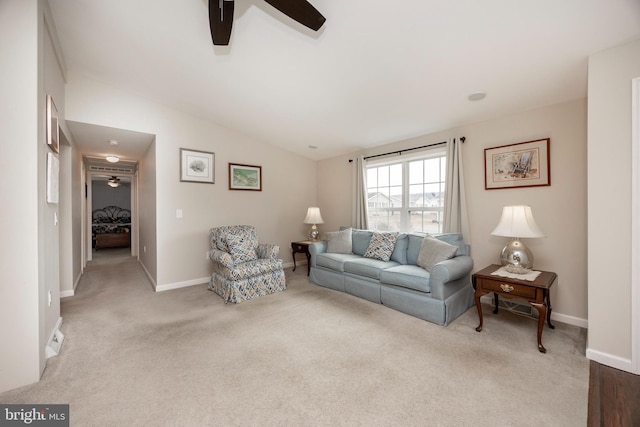 living area featuring lofted ceiling, carpet floors, a ceiling fan, and baseboards