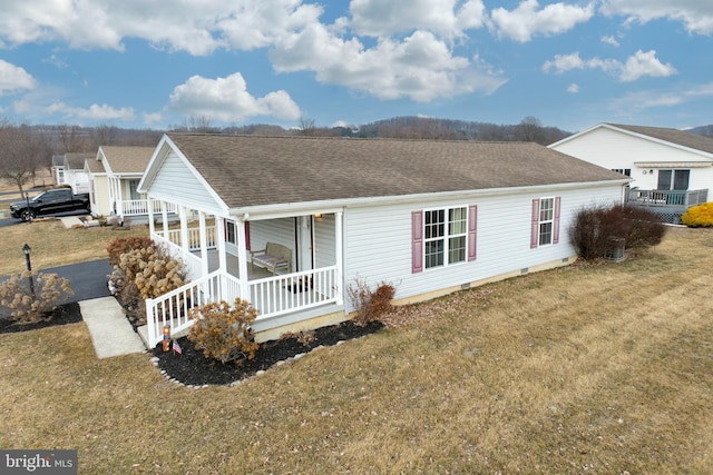 view of front facade with crawl space, a shingled roof, a porch, and a front yard