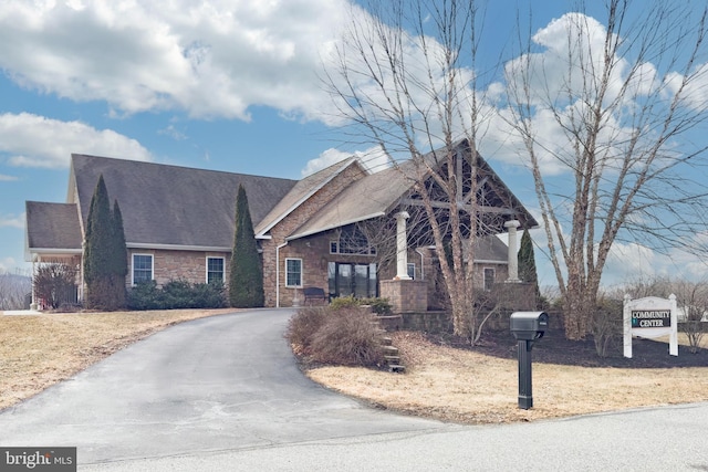 view of front of house with stone siding and aphalt driveway