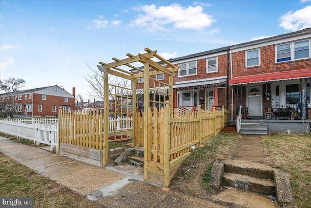 view of property featuring brick siding and fence