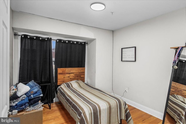 bedroom featuring wood finished floors and baseboards