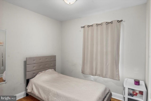 bedroom featuring baseboards and wood finished floors