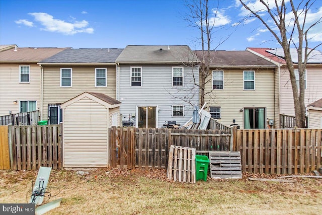 back of house with a yard, a fenced backyard, and an outdoor structure