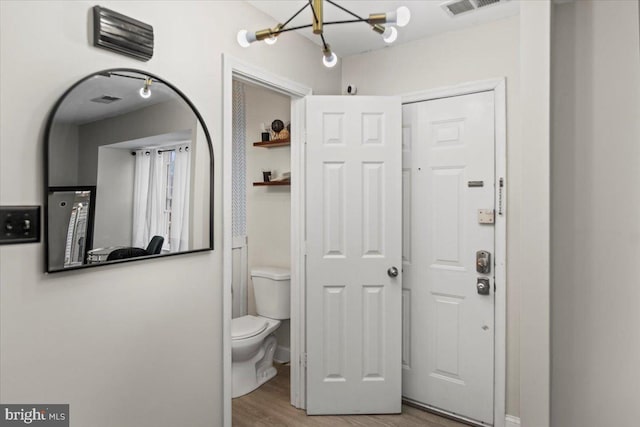 bathroom featuring toilet, visible vents, and wood finished floors