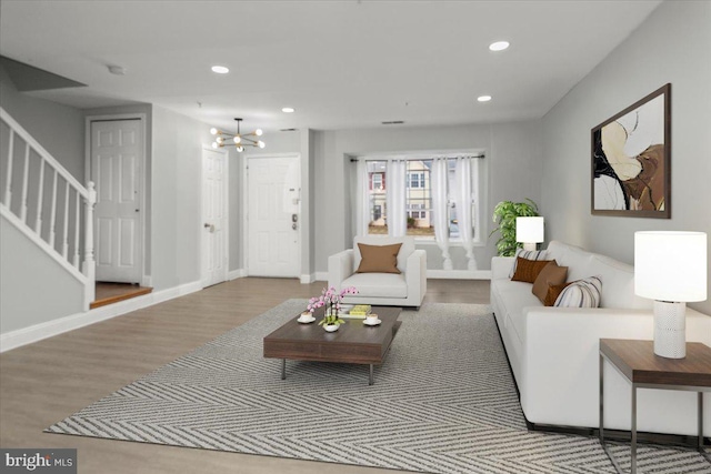 living room with recessed lighting, wood finished floors, baseboards, and stairs