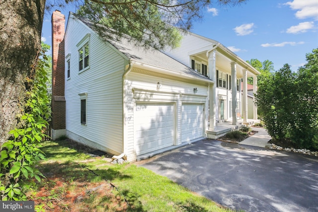 1729 Hutchinson Ln, Silver Spring, MD 20906 - view of home's exterior with asphalt driveway, a chimney, a garage, and a shingled roof