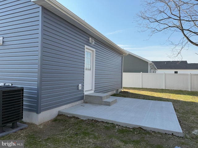 view of home's exterior featuring a lawn, entry steps, a patio, central AC, and fence