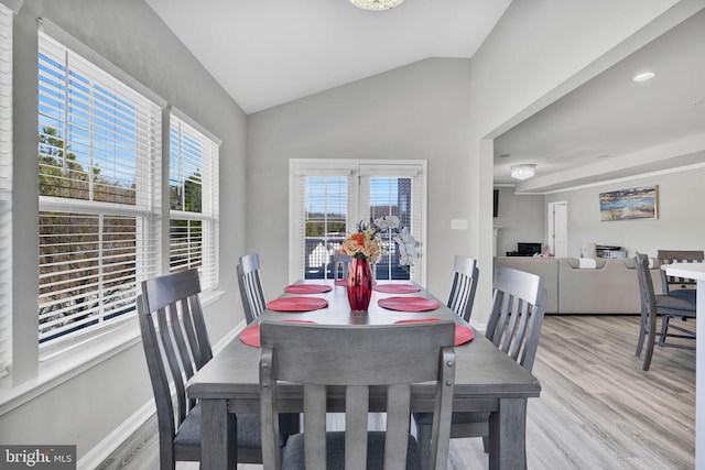 dining area with vaulted ceiling, wood finished floors, and baseboards