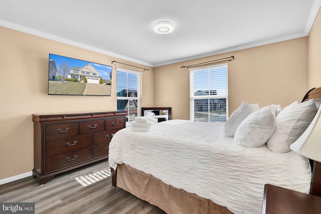 bedroom featuring baseboards, wood finished floors, and ornamental molding