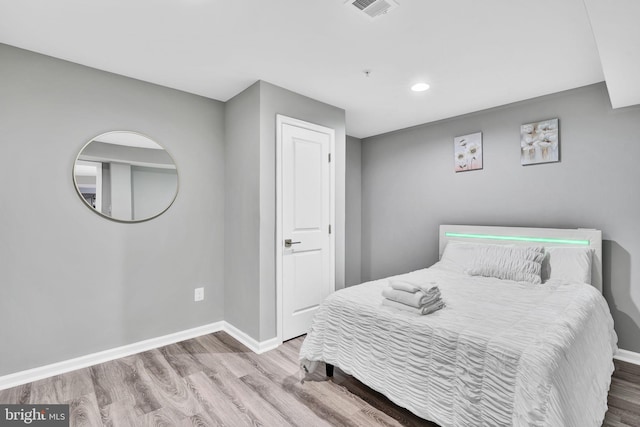 bedroom featuring visible vents, baseboards, and wood finished floors